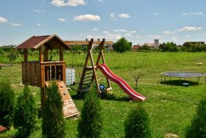 einen Spielplatz mit Rutsche und Spielstruktur in der Unterkunft La foisor in Turda