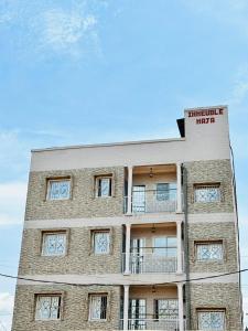 - un grand bâtiment en briques avec un balcon dans l'établissement Appartement haut standing ,Biyem Assi TKC, à Yaoundé