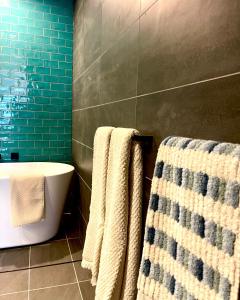 a bathroom with a bath tub and towels on a wall at Ollies Place in Gold Coast