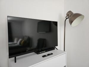 einen Flachbild-TV auf einem weißen Schrank in der Unterkunft Gemütliche Wohnung in ruhigem Wohngebiet in Aschaffenburg