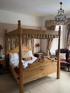 a bedroom with a canopy bed and a chair at Baytree House in Lowestoft