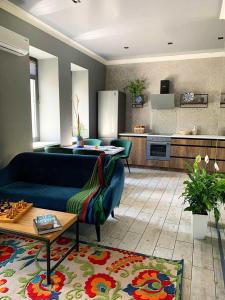 3 Rooms VIP Apartment on Metallurgov 5 في زاباروجيا: غرفة معيشة مع أريكة زرقاء ومطبخ