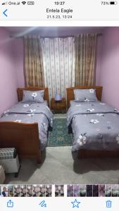 two beds sitting next to each other in a room at Appartamento centro in Pogradec