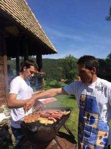 的住宿－Apartman Misailovici 2，两个男人在烤架上做饭