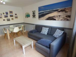 un soggiorno con divano e tavolo di Casa DENNY - Oasis Papagayo a Corralejo
