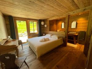 a bedroom with a bed in a wooden cabin at Alpen Charme - Chalet d'Hôtes et SPA in Gsteig