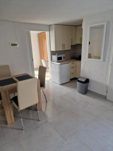 a kitchen with a table and chairs in a room at Apartman Bella in Drage