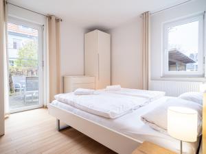um quarto branco com uma cama grande e uma janela em Grüne Straße FeWo G6 (EG rechts) em Prerow