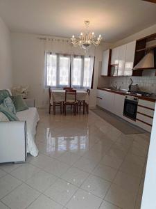 a kitchen and living room with a table and a chandelier at Bertos house tra mare e laguna in Cavallino-Treporti