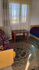 a room with a bed and a table and a window at Guest house Umar in Tong
