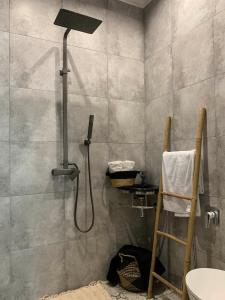 a shower with a shower head in a bathroom at 3 Rooms VIP Apartment on Metallurgov 5 in Zaporozhye