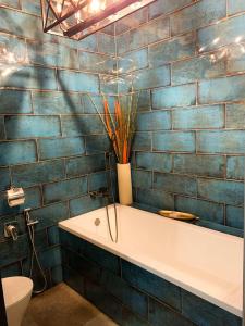 3 Rooms VIP Apartment on Metallurgov 5 في زاباروجيا: حمام من البلاط الأزرق مع حوض استحمام ومرحاض