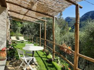 un patio con tavolo e sedie in giardino di Contrada Bolla 2 a Finale Ligure