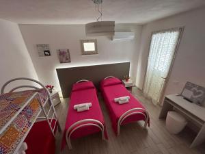 1 dormitorio con 2 camas y almohadas rosas en B & B Da Rosa, en Petrosino