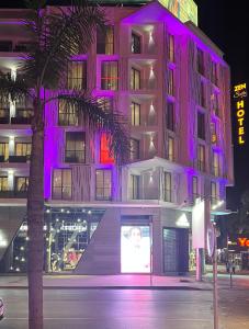 Un bâtiment avec des lumières violettes sur son côté dans l'établissement ZEN Suites Hotel Massira, à Casablanca