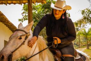 een vrouw met een cowboyhoed op een wit paard bij West Water Park in Santo Antônio do Pinhal
