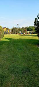 a large grassy field with a playground in the background at Domki Apartamentowe WIKING in Władysławowo