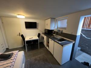 ein kleines Zimmer mit einer Küche, einem Tisch und einem Bett in der Unterkunft 1 Room in Hannover