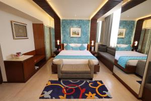 a hotel room with two beds and a couch at Regenta Orkos Kolkata by Royal Orchid Hotels Limited in Kolkata