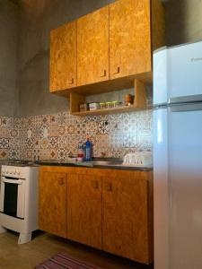 a kitchen with wooden cabinets and a white refrigerator at Flats Macapá Meu Amor in Luis Correia