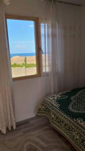a bedroom with a window with a view of the desert at Guest house Umar in Tong