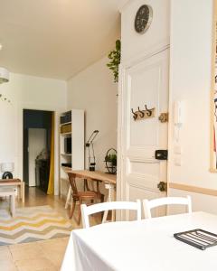 cocina y comedor con reloj en la pared en Bel appartement centre ville Sète, en Sète