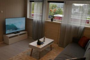 un soggiorno con TV e tavolino da caffè di Nyrenovert leilighet med gratis parkering a Leknes