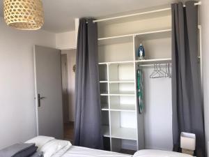 een slaapkamer met een bed en een boekenplank bij T2 50m2 3*,centre ville,calme,lumineux charme in Rodez