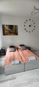 a bedroom with a bed with a clock on the wall at LIBERation! in Olsztyn