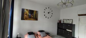 a bedroom with a bed and a clock on the wall at LIBERation! in Olsztyn