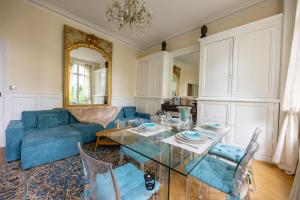 un salon avec un canapé bleu et une table en verre dans l'établissement Terrasse Royale au Coeur de Nantes, à Nantes
