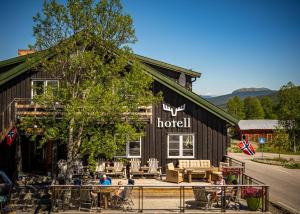 a hotel with people sitting at tables outside of it at Skåbu Fjellhotell in Skåbu