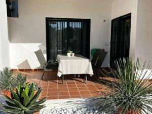 une terrasse avec une table, des chaises et des plantes dans l'établissement Ruim appartement, zonnig terras, Alhaurin Golf!, à Alhaurín el Grande