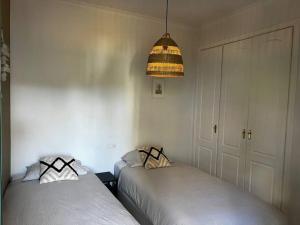 een slaapkamer met 2 bedden en een lamp bij Ruim appartement, zonnig terras, Alhaurin Golf! in Alhaurín el Grande