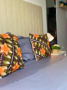 a bed with two pillows on top of it at Quarto Nº5 FANTASTIQUE- Central Praia in Praia