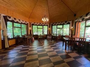 a dining room with tables and chairs on a checkered floor at Grunok (Adults only) in Pilipets