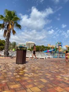 a man walking past a trash can next to a playground at Beautiful apartment in Salou with pool access in Salou