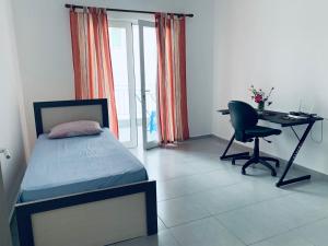 a bedroom with a bed and a desk and a chair at Apartment in Gramsh
