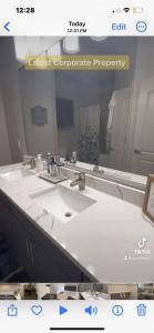 ein Badezimmer mit zwei Waschbecken und einem großen Spiegel in der Unterkunft Stress Free Living 3br 2ba in Orlando