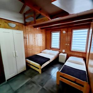 a bedroom with two beds and two windows at Ośrodek 9Amber in Pobierowo