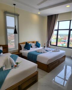 Habitación de hotel con 2 camas y ventana en Romano Hotel en Kampot
