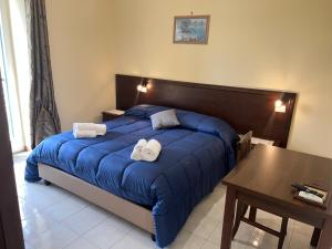 a bedroom with a blue bed with towels on it at Agriturismo Le Grottelle in SantʼAgata sui Due Golfi