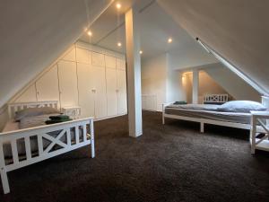 un dormitorio en el ático con 2 camas y una escalera en Villa Arche 3, en Neuenkirchen-Vörden