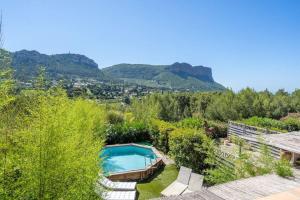 a swimming pool in a garden with mountains in the background at Just in Cap Canaille in Cassis