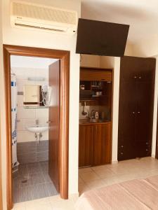 eine Küche mit einer Spüle und einer Mikrowelle in der Unterkunft VILLA HARIKLIA in Paralia Katerinis