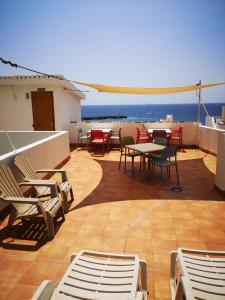 a patio with chairs and tables and a view of the ocean at Apartamentos La Fuente in Santa Cruz de la Palma