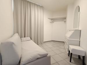 biały pokój z łóżkiem i komodą w obiekcie Attico al Centro w Cefalù