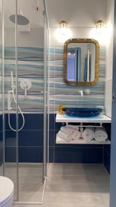 ein Bad mit einer Dusche, einem Waschbecken und einem Spiegel in der Unterkunft Sunrise B&B Le castella in Le Castella