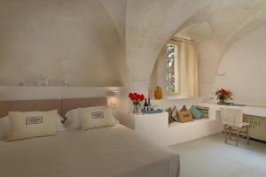 a white bedroom with a bed and a window at Masseria Cuturi in Manduria +210 photos