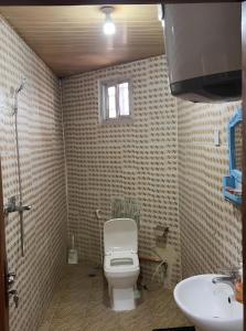 a bathroom with a toilet and a sink at Yogi Guesthouse Most Affordable, Decent and Nearest accommodation near Airport with Wifi and hot showers in Freetown +34 photos